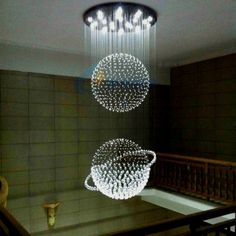 a chandelier hanging from the ceiling in a room with tile walls and stairs