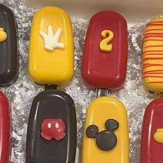 a box filled with lots of different types of cake covered in fondant and mickey mouse decorations