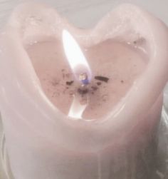 a heart shaped candle with a lit candle in it