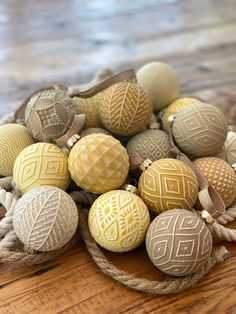 a bunch of balls sitting on top of a wooden table next to rope wrapped around each other