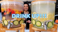 two large buckets filled with drinks sitting on top of wooden stands next to each other