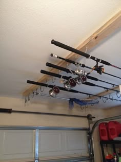 there are many fishing rods hanging from the ceiling above the garage door and overhead storage area