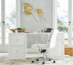 a white chair sitting in front of a desk with gold leaf decorations on the wall