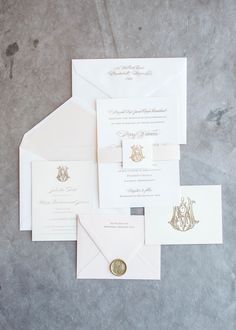 the wedding stationery is laid out on top of each other, including an envelope with a wax seal