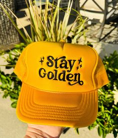 "Stay Golden" black threaded design embroidered on a foam trucker hat. The perfect accessory to make a bold statement! Ships within 3-5 business days. Gold Trucker Hat For Streetwear, Trendy Snapback Trucker Hat With Embroidered Logo, Yellow Snapback Trucker Hat With Letter Print, Yellow Letter Print Snapback Trucker Hat, Trendy Embroidered Trucker Hat, Gold Snapback Trucker Hat For Streetwear, Adjustable Gold Trucker Hat For Streetwear, Gold Snapback Trucker Hat, Embroidered Trucker Hat For Streetwear