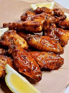 chicken wings with lemon wedges and ketchup on a paper plate, ready to be eaten