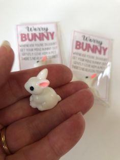 a person is holding two bunny erasers in their hand