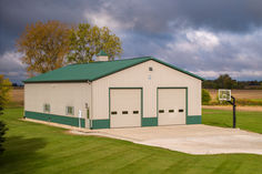 a green and white building sitting on top of a lush green field next to a basketball hoop