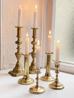 a group of candles sitting on top of a window sill