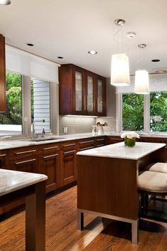 a large kitchen with wooden cabinets and white counter tops, along with hardwood flooring