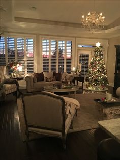 a living room filled with furniture and a christmas tree in the middle of the room