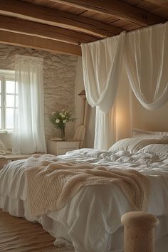 a white bed sitting in a bedroom next to a window with curtains on top of it