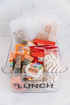 a plastic container filled with lots of candy and candies on top of a table