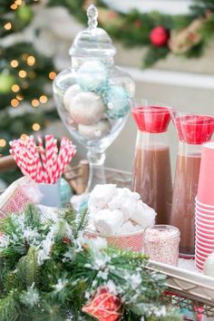 a basket filled with lots of candy next to a christmas tree and other holiday decorations