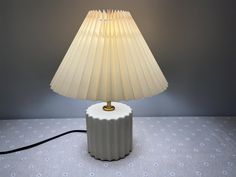 a lamp that is sitting on top of a table next to a wallpapered floor