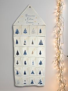 a wall hanging on the side of a white wall next to a christmas tree decoration