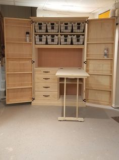 an empty room with shelves, desk and storage bins