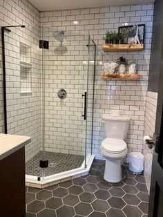 a white toilet sitting next to a walk in shower