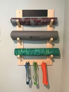 a wall mounted rack with yoga mats and umbrellas