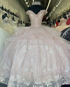 a dress on display in a store with other gowns and dresses for sale behind it