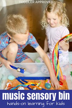 two young children playing with toys in a play box that says music sensory bin hands - on learning for kids