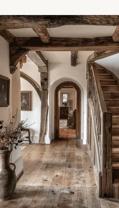 a hallway with wooden floors and stairs leading up to the second floor in an old style home