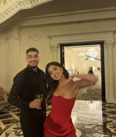 a man and woman standing next to each other in front of a marble floored room