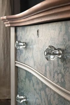 an ornate dresser with silver handles and drawers