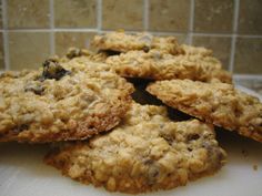 three oatmeal cookies are stacked on top of each other in front of a tiled wall