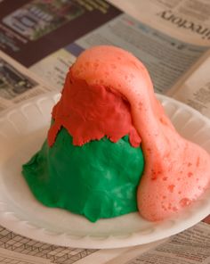 a cake shaped like a mountain on a paper plate with newspaper in the back ground