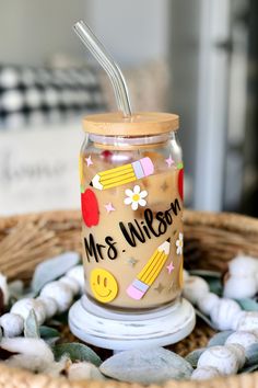 a jar with a straw in it sitting on top of a basket filled with shells