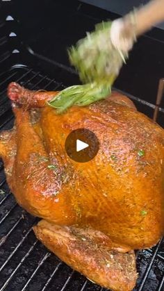 a turkey being cooked on the grill with a knife