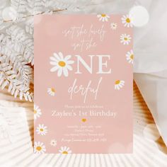 a pink birthday party card with daisies and the words wild one written on it