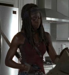 a woman with dreadlocks standing in a kitchen