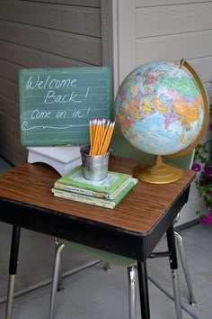 a desk with a globe, books and pencils on it