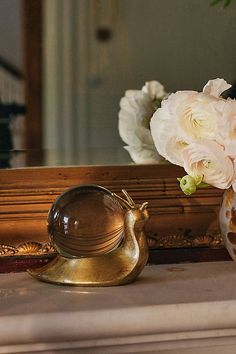 a vase filled with white flowers sitting on top of a table next to a mirror