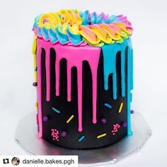 a colorful cake with icing and sprinkles on the top is shown