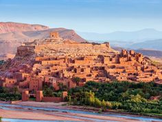 an old village in the desert surrounded by trees and mountains with no people on it