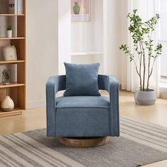 a blue chair sitting on top of a wooden floor next to a book shelf filled with books