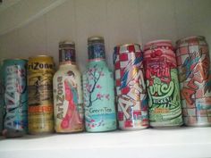 many different types of cans are lined up in a row on top of a shelf