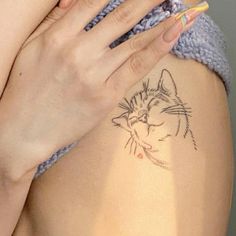 a close up of a person with a cat tattoo on her arm and the other hand