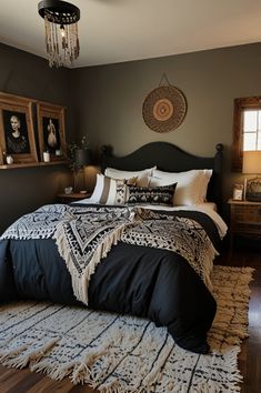 a bed with black and white comforter in a bedroom next to two pictures on the wall