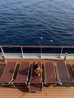 a woman is sitting on the deck of a cruise ship