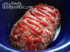 the meatloaf is covered with ketchup in a blue bowl