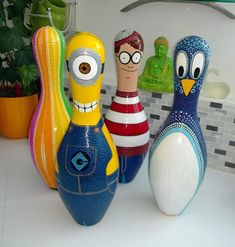 three colorful bowling pins sitting next to each other on top of a white countertop