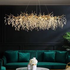 a living room with green couches and a chandelier hanging from the ceiling