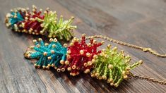 three colorful necklaces sitting on top of a wooden table