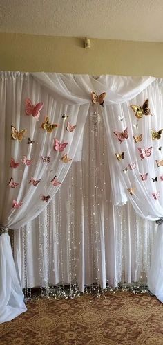 a white curtain with butterflies hanging from it's sides and curtains on the side