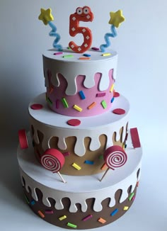 a three tiered cake with colorful icing and sprinkles