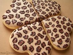 four cookies with chocolate and white frosting in the shape of an animal print pattern